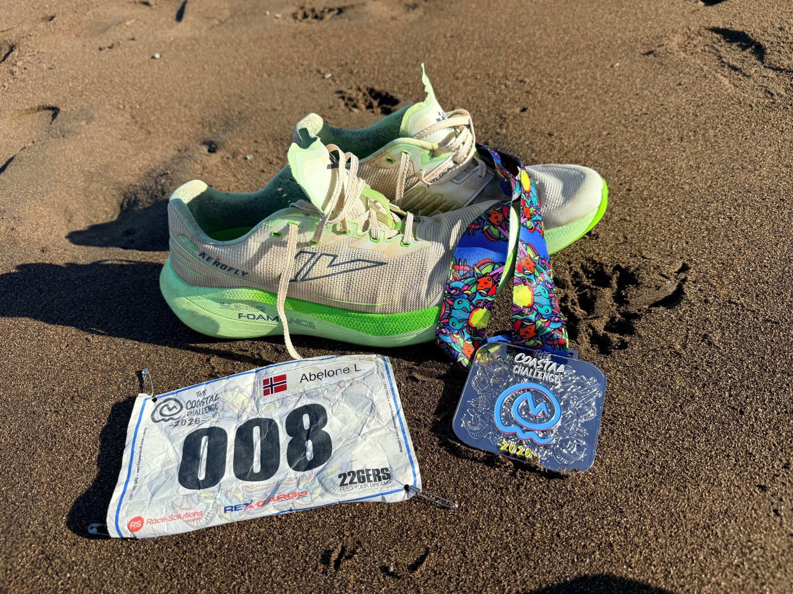 VJ Fuzion Aerofly sko med The Coastal Challenge Costa Rica medalje og startnummer på strand.