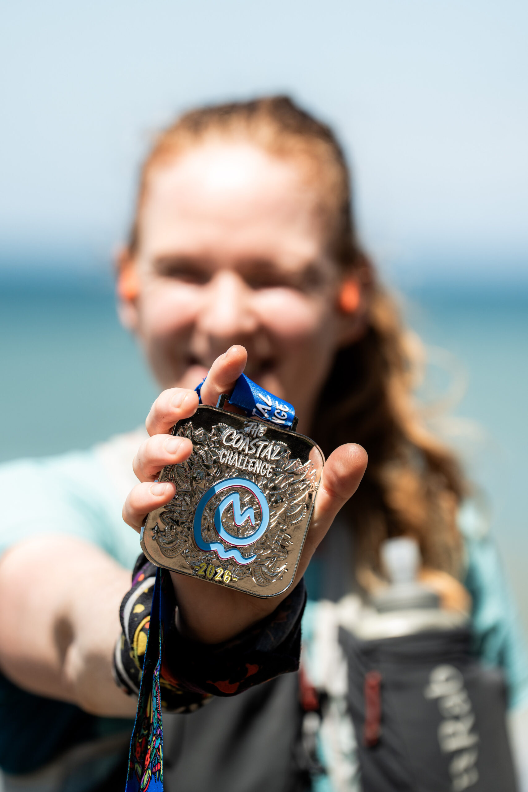 Løper med medalje i hånden