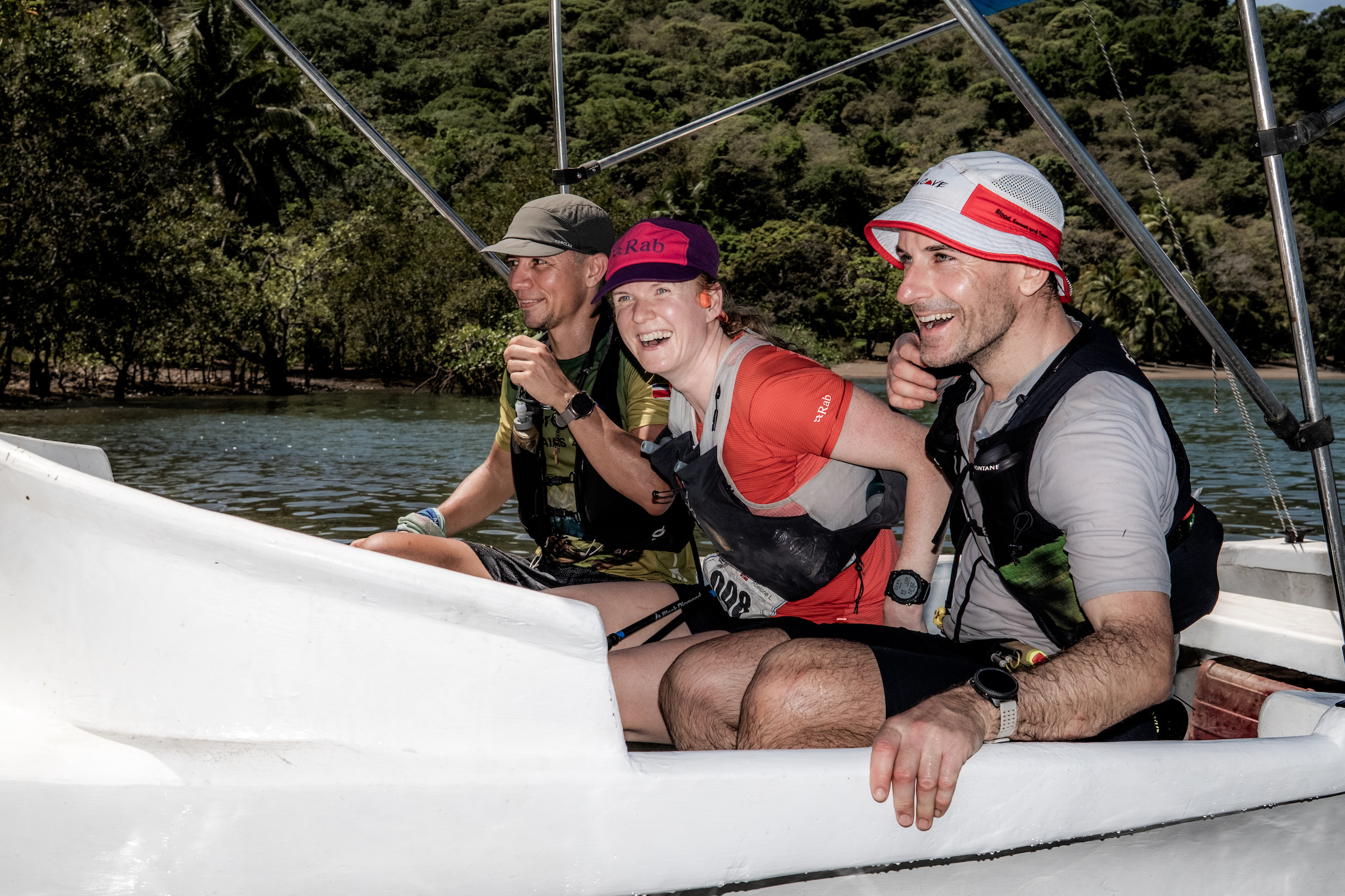 Tre løpere i speedbåt krysser elv med krokodiller i.