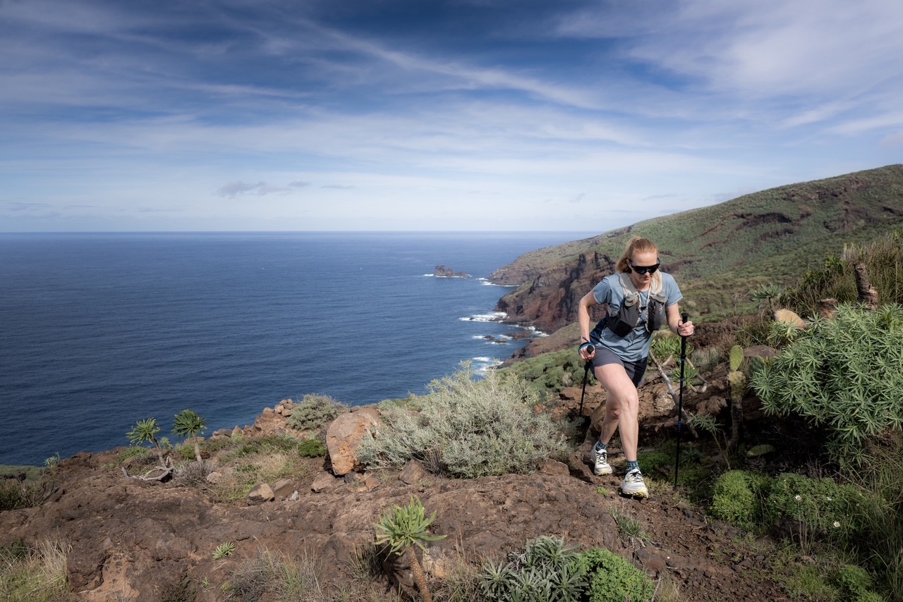 Abelone Lyng på vei oppover i terrenget på øya La Palma med havet i bakgrunnen