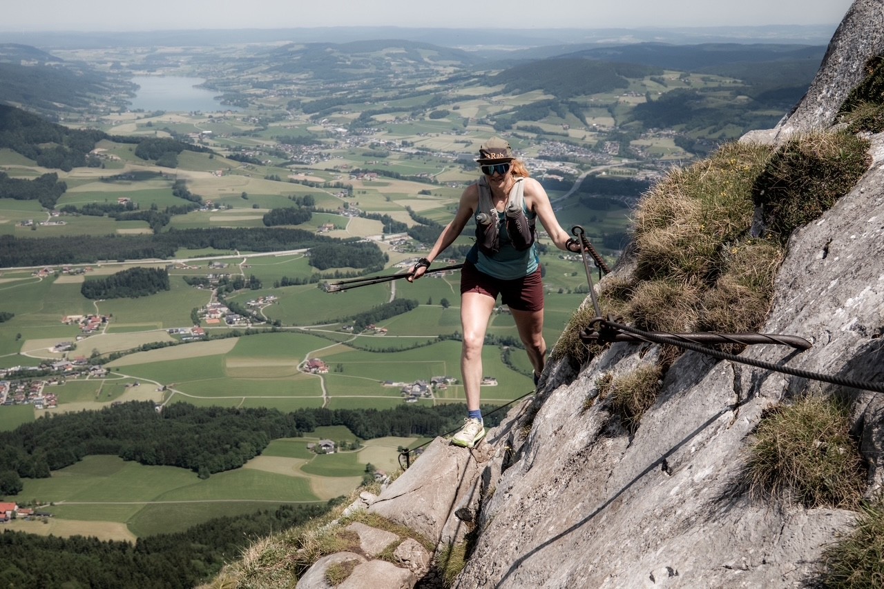 Abelone lyng på via ferata på vei opp fjellet Schober med utsikt over grønt kulturlandskap i bakgrunnen
